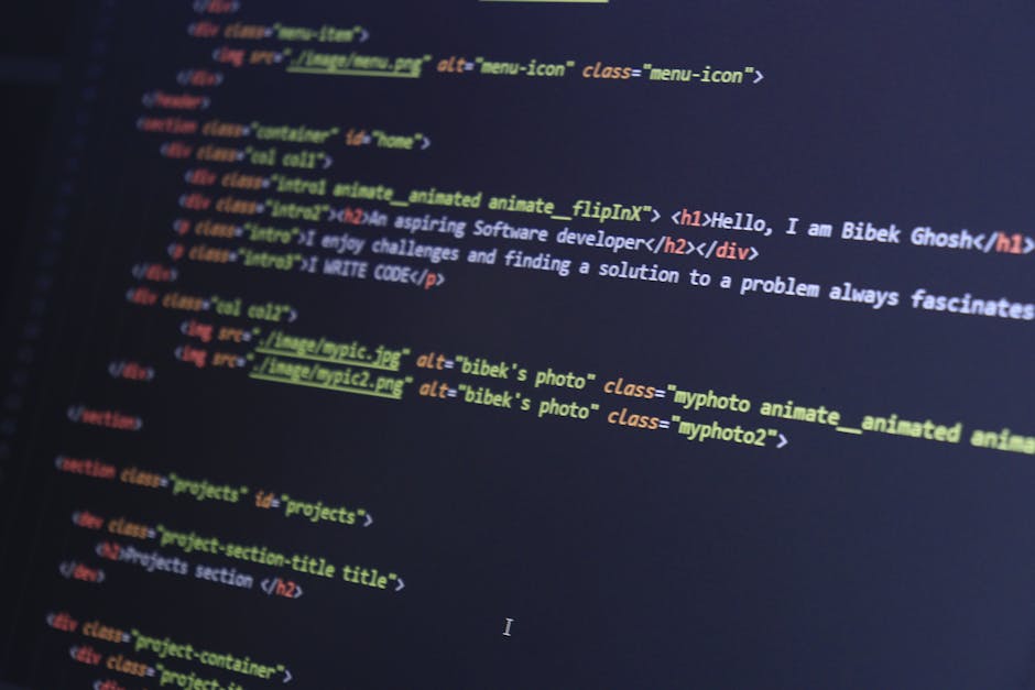 A photograph displays a close-up view of a computer screen showing lines of HTML code with syntax highlighting in various colors. The code includes tags and attributes related to images, such as 'alt'
